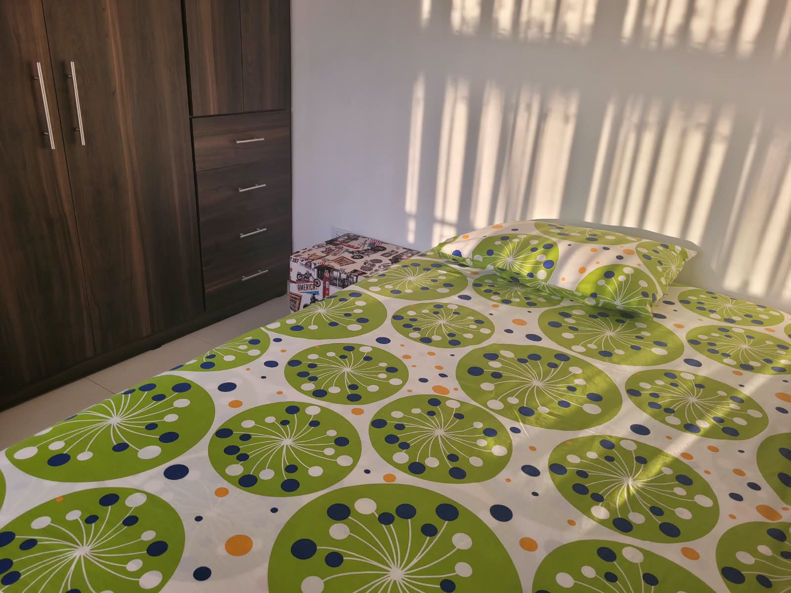Habitación luminosa con cama de estampado verde