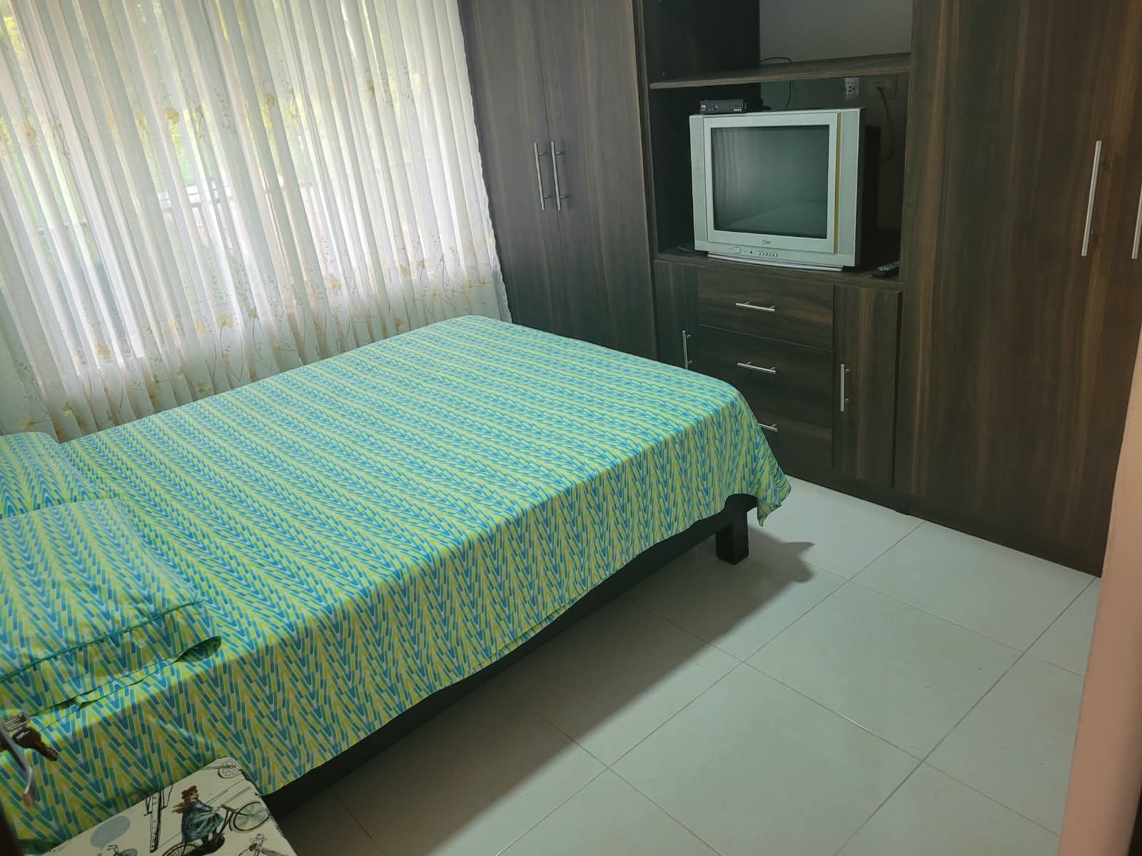 Habitación con cama, televisor y closet