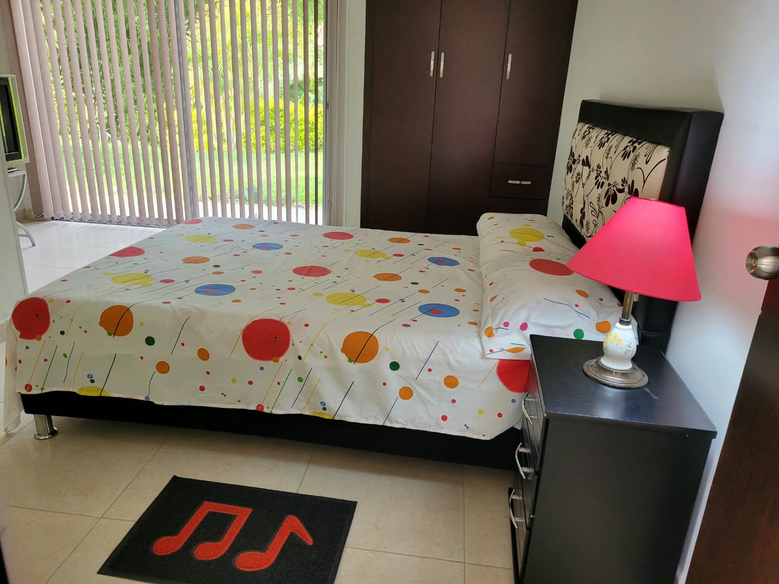 Habitación con cama doble y ventanal al jardín