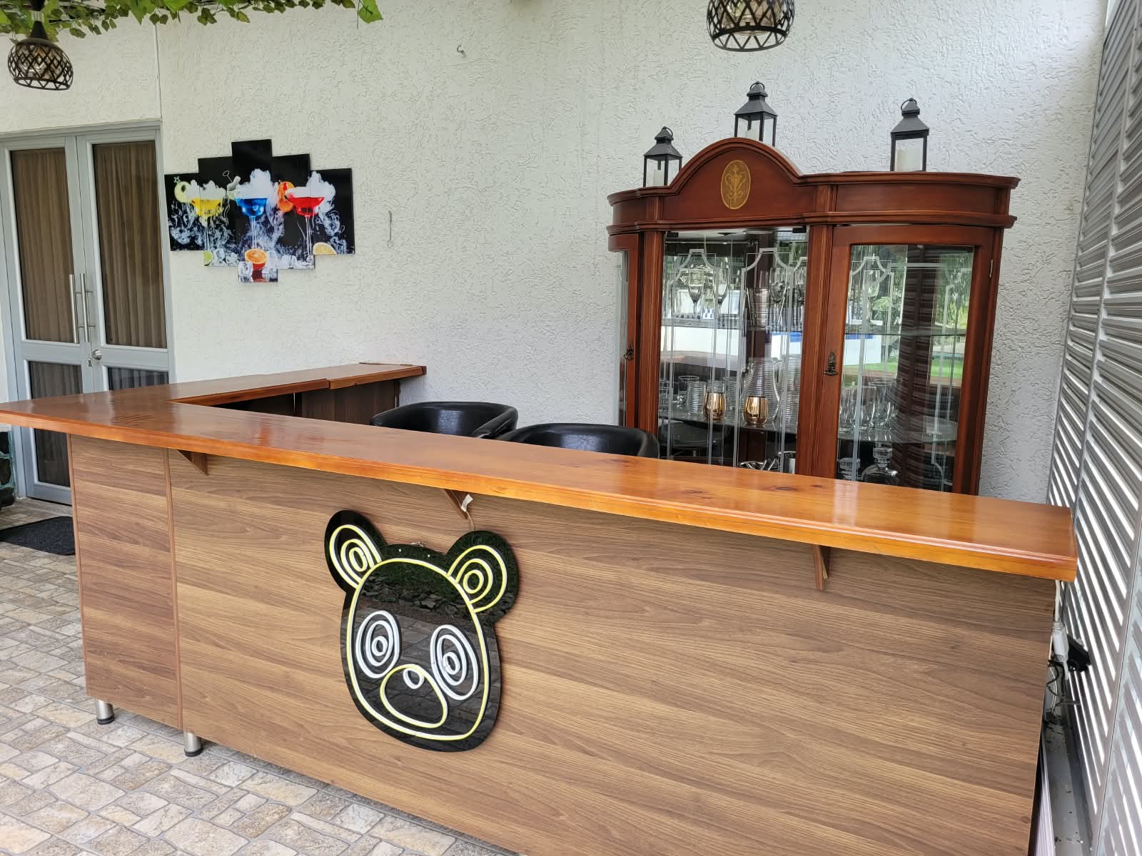 Bar con barra de madera y logo del panda en neón