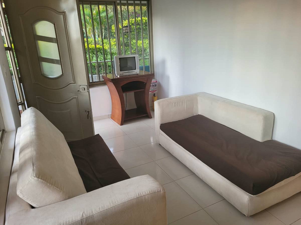 Sala de la cabaña con dos sofás y TV