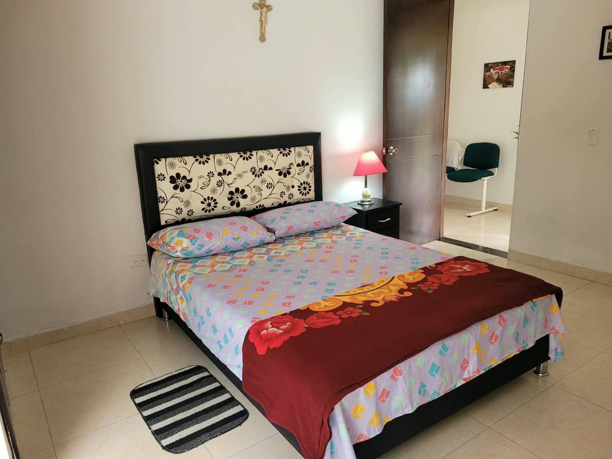 Habitación con cama doble y cabecero floral
