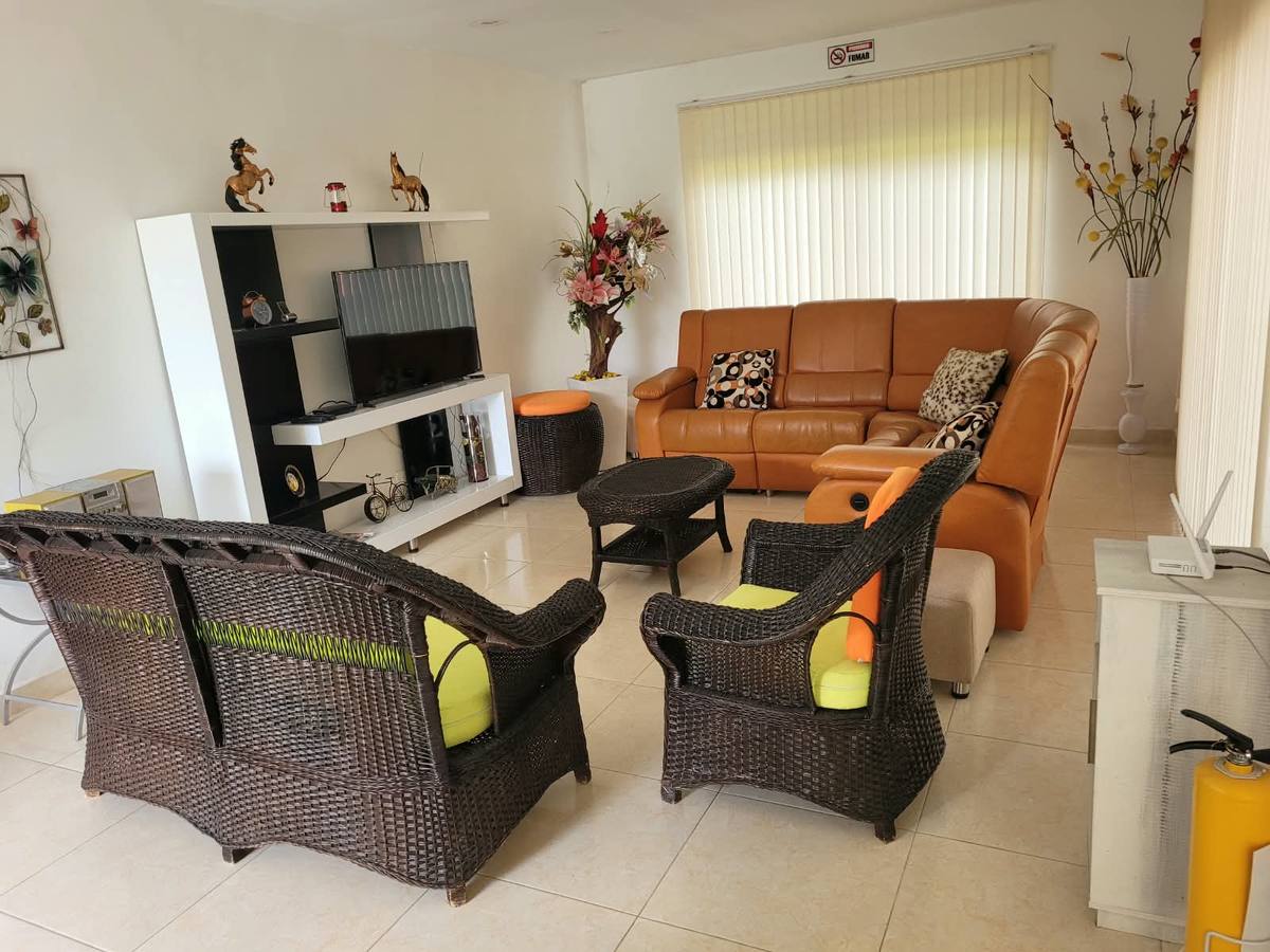 Sala con sofá reclinable y mecedoras de mimbre