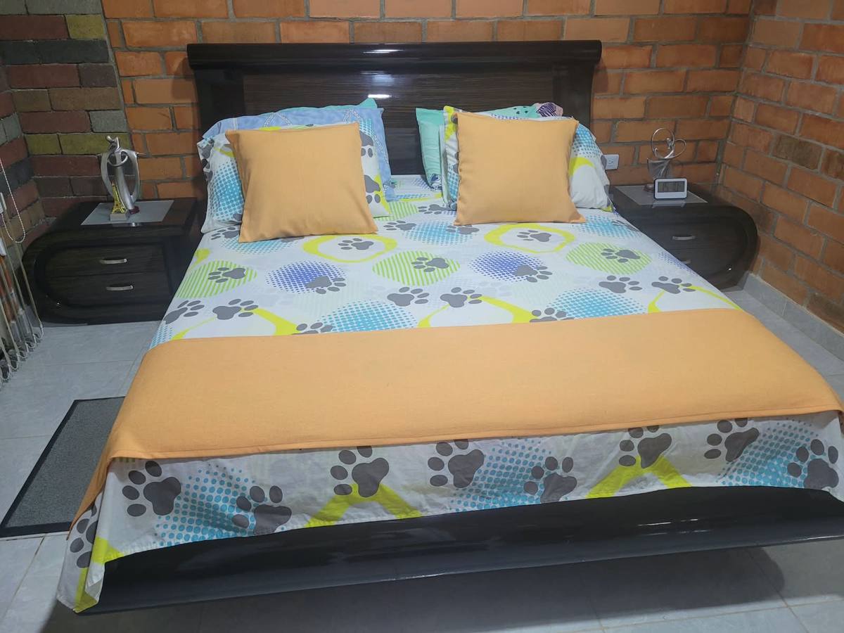 Habitación con cabecero y pared de ladrillo
